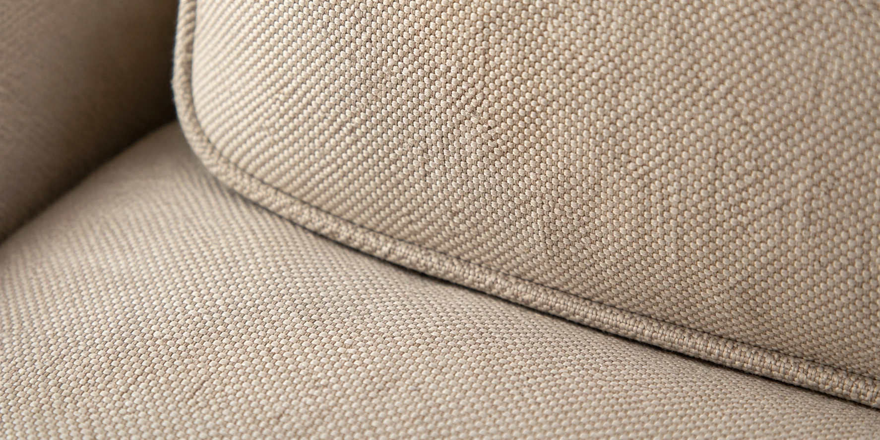 Close-up texture of a woven fabric sofa in a neutral tone