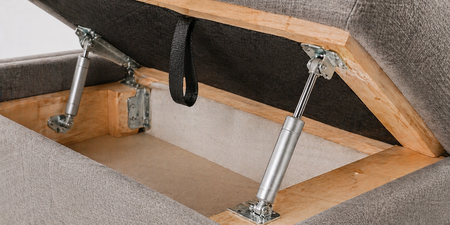 Close-up of gas strut hydraulic mechanism on a lift-up storage sofa