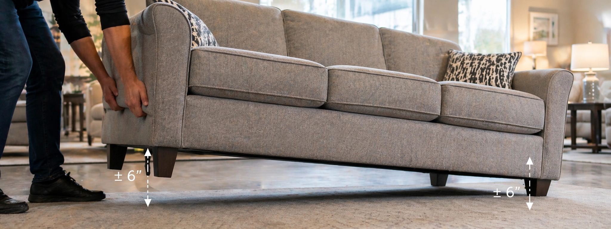 Person performing the lift test to check sofa frame quality in a furniture showroom