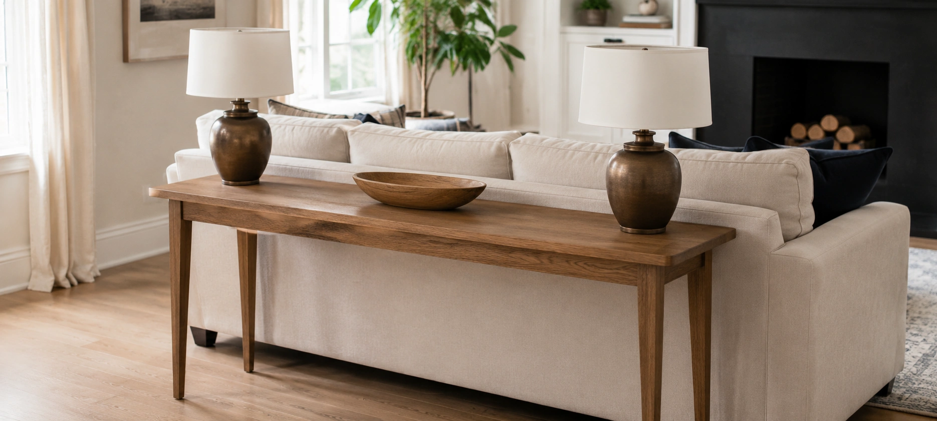 Console sofa table behind a sectional with lamps and decor