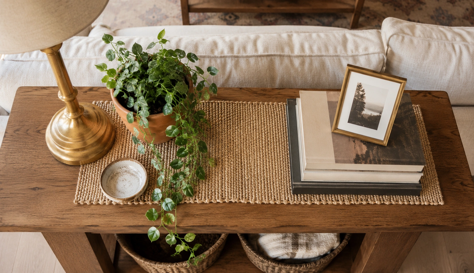Beautifully styled sofa table with lamps books and decor items