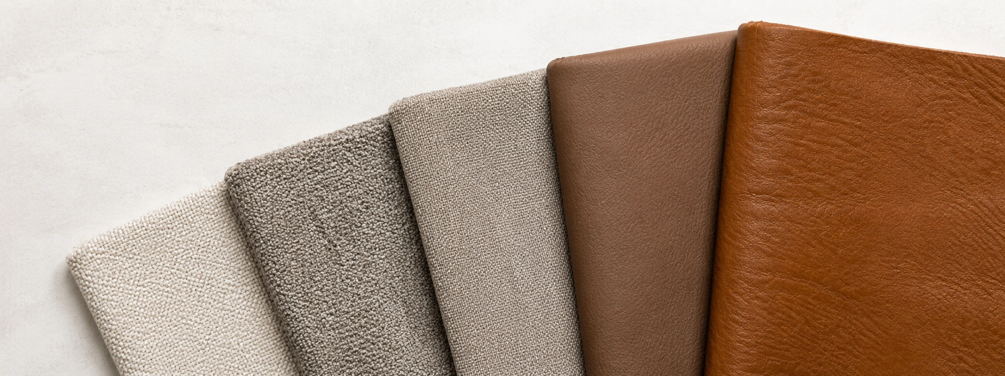 Different sofa upholstery materials arranged by price from budget polyester to luxury top-grain leather